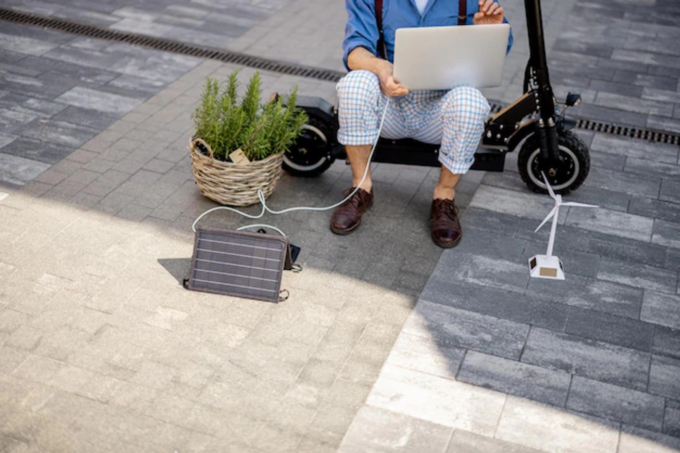 man charging laptop with portable solar panel
