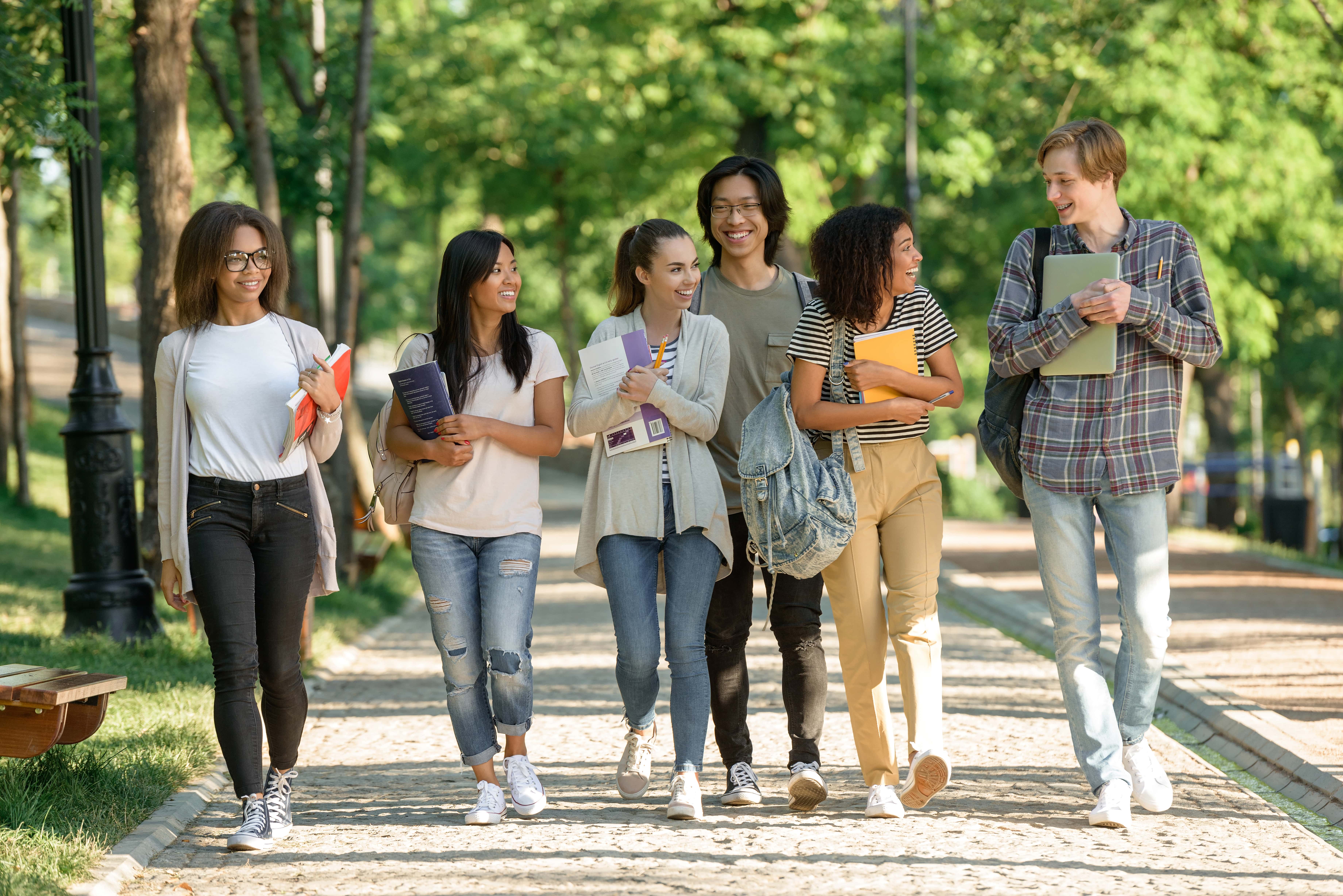 A group of students traverse campus with school materials.