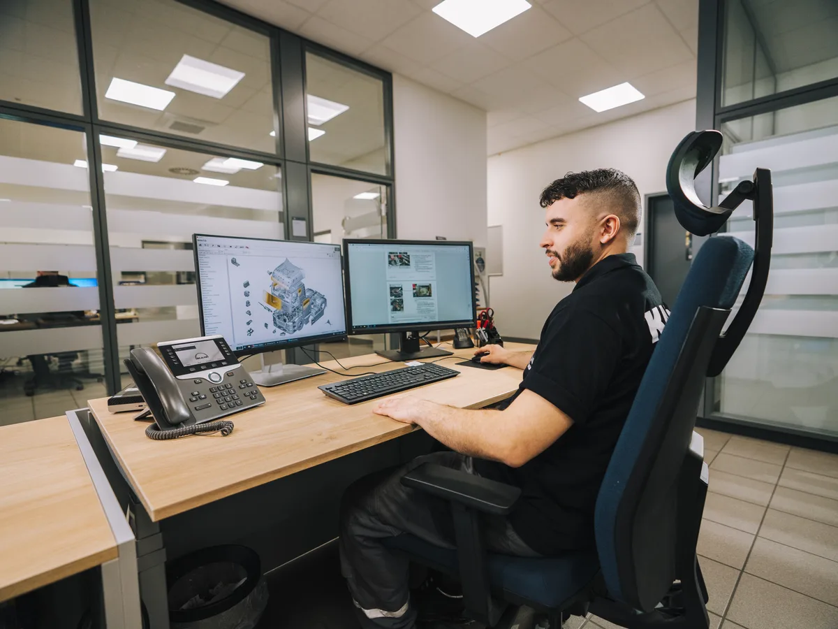 Mitarbeiter am Arbeitsplatz mit MAN-Fachsoftware am Bildschirm