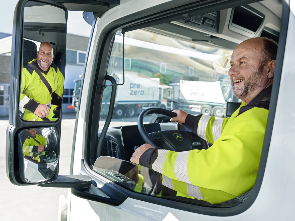 PreZero Fahrer lacht aus dem Fahrerhaus