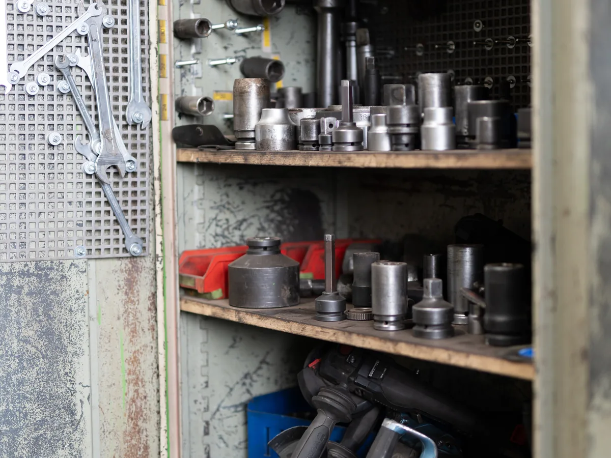Mechaniker an der Werkzeugwand in der Werkstatt
