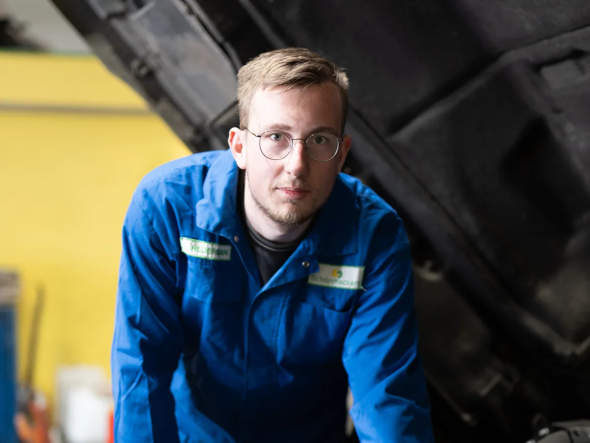 Mechaniker bei der Arbeit unter der Motorhaube eines Entsorgungsfahrzeugs