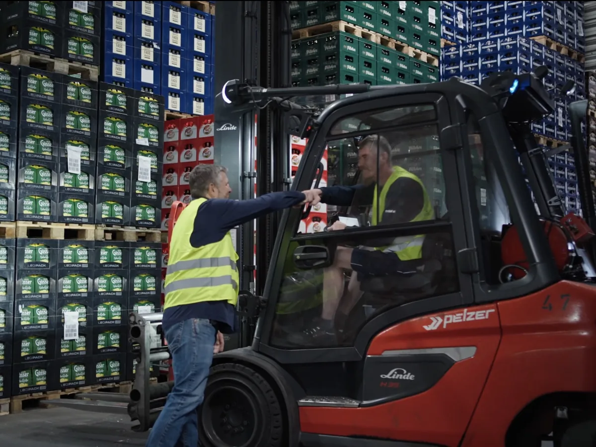 Kollegen im Lager bei der Übergabe
