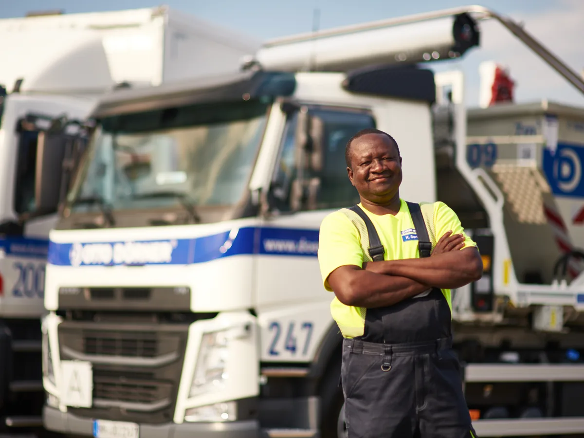 Fahrer in Warnkleidung vor dem Lkw