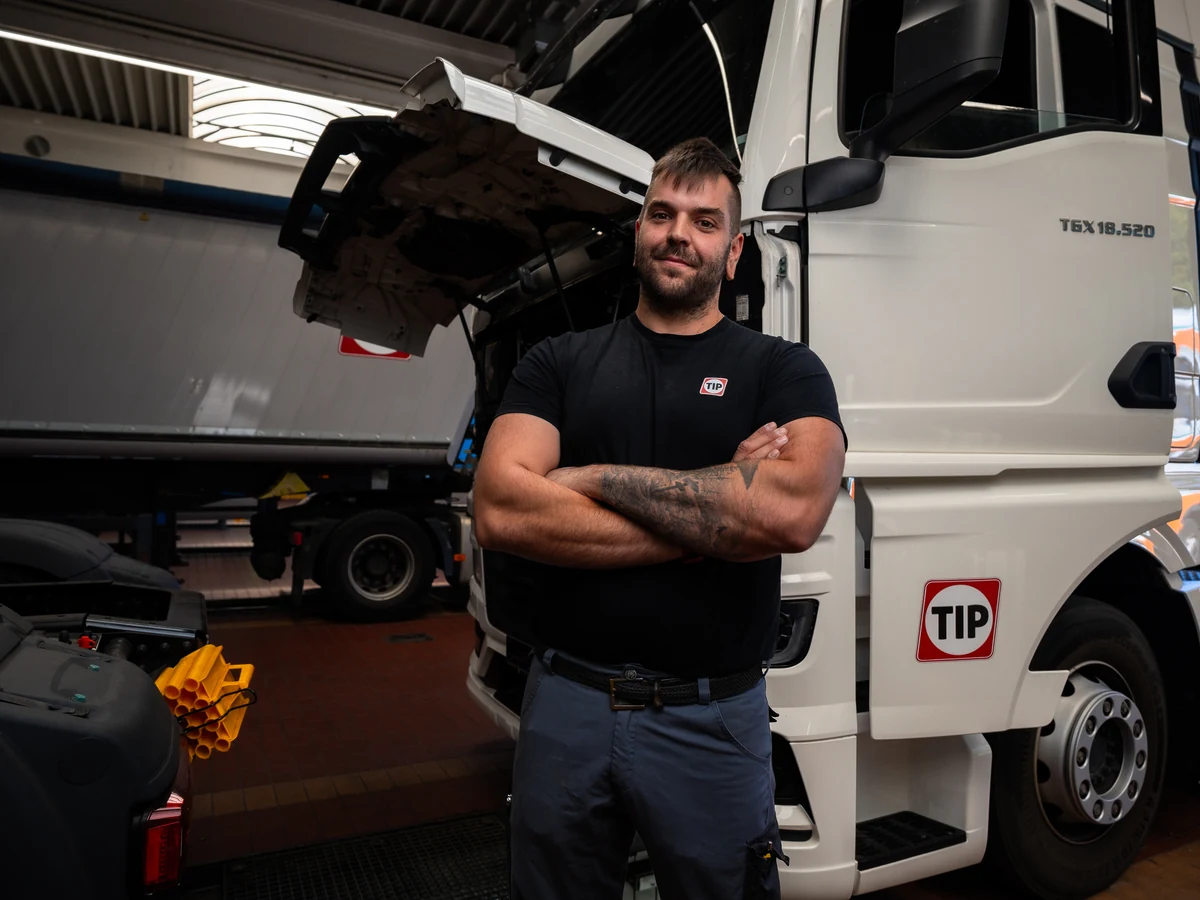 TIP Mechatroniker mit verschr&auml;nkten Armen vor dem Lkw