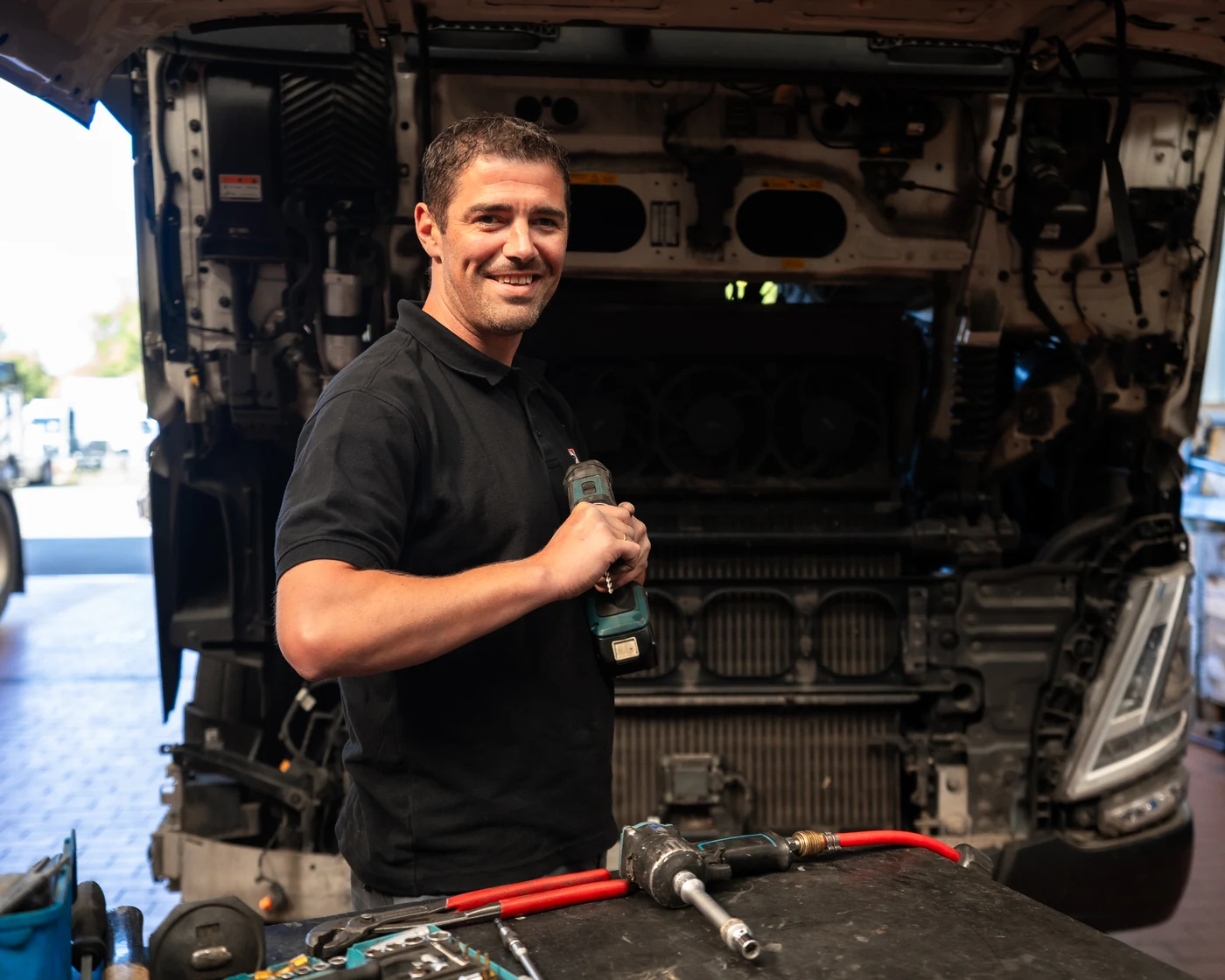 TIP Mechatroniker mit Akkuschrauber am Motorraum