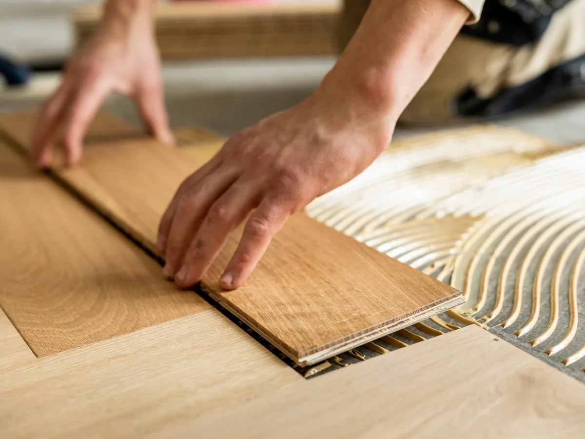 Handwerker legt exakt ein Element an die Unterkonstruktion an