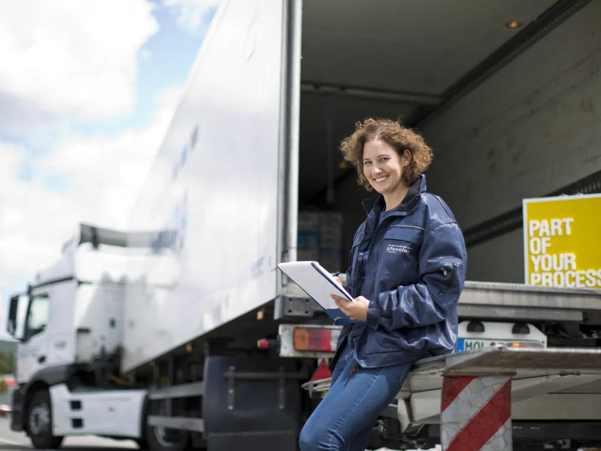 Fahrerin lehnt an einem Pfenning-LKW