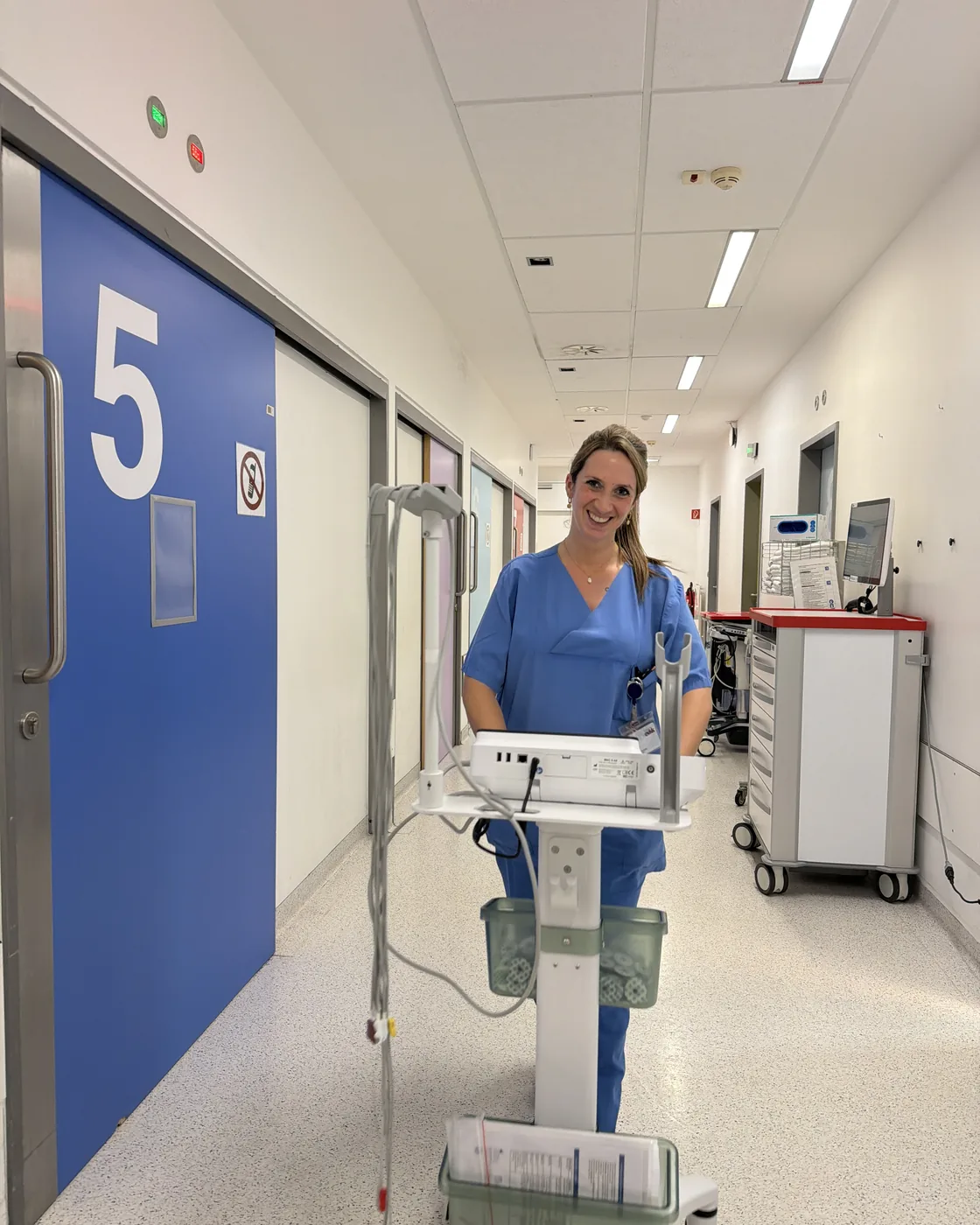 Pflegefachkraft mit EKG-Wagen