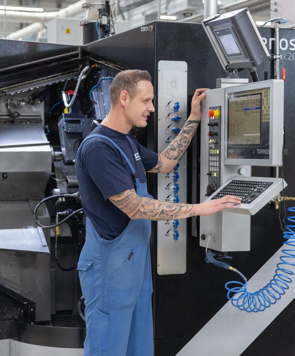 Mitarbeiter an der Steuerung einer CNC-Maschine