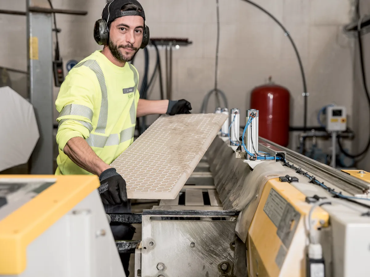 Kollege an der Bearbeitungsmaschine in der Halle