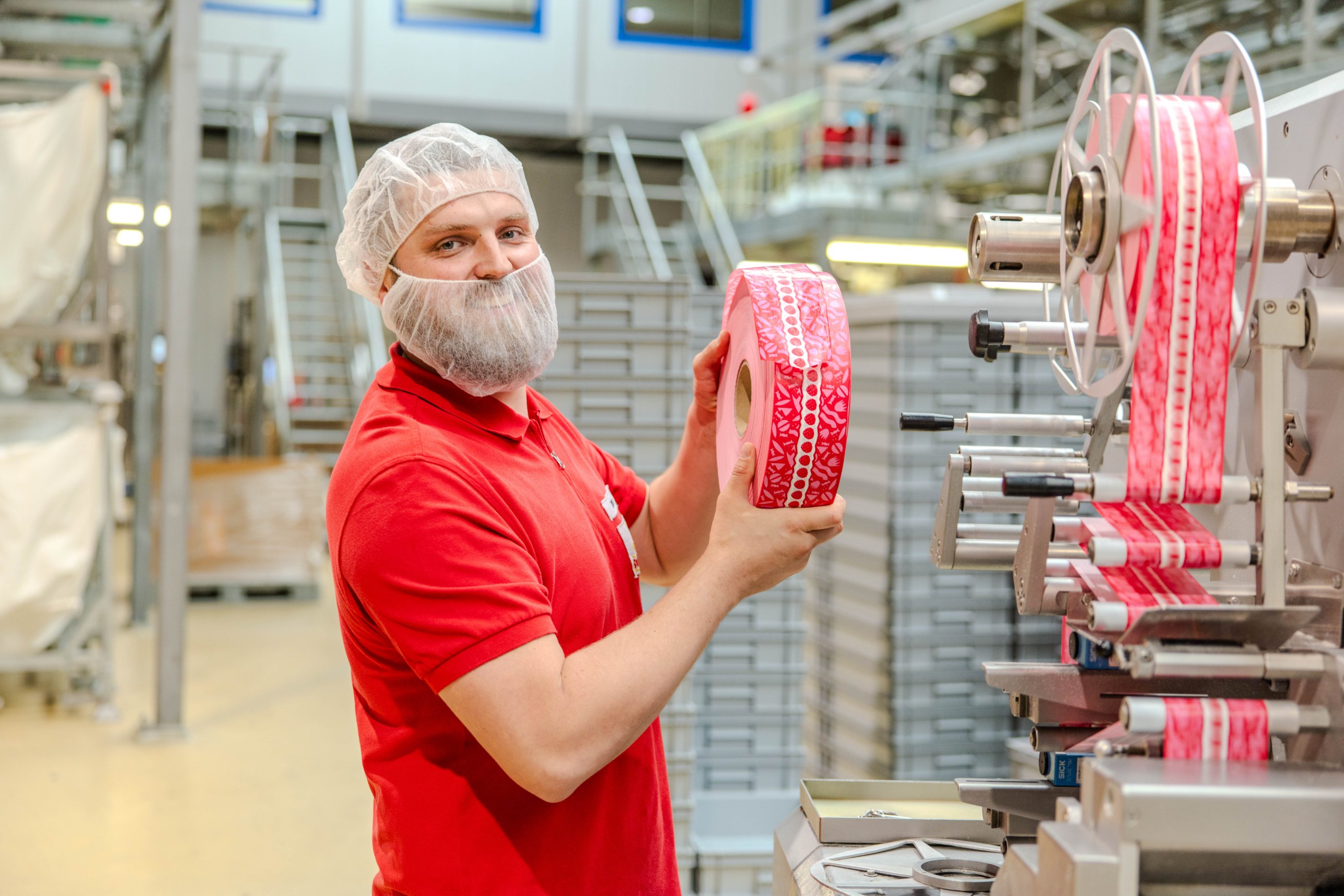 Sweet Tec Mitarbeiter mit Verpackungsband an der Schlauchbeutelmaschine