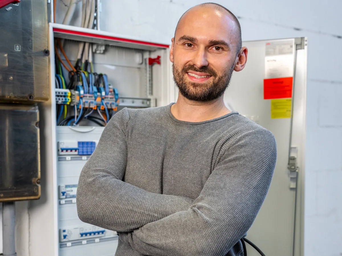 Kögel Elektroniker steht an einem Schaltschrank