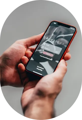 Person holding a smartphone displaying a login screen for the Physiorx app with email and password fields.