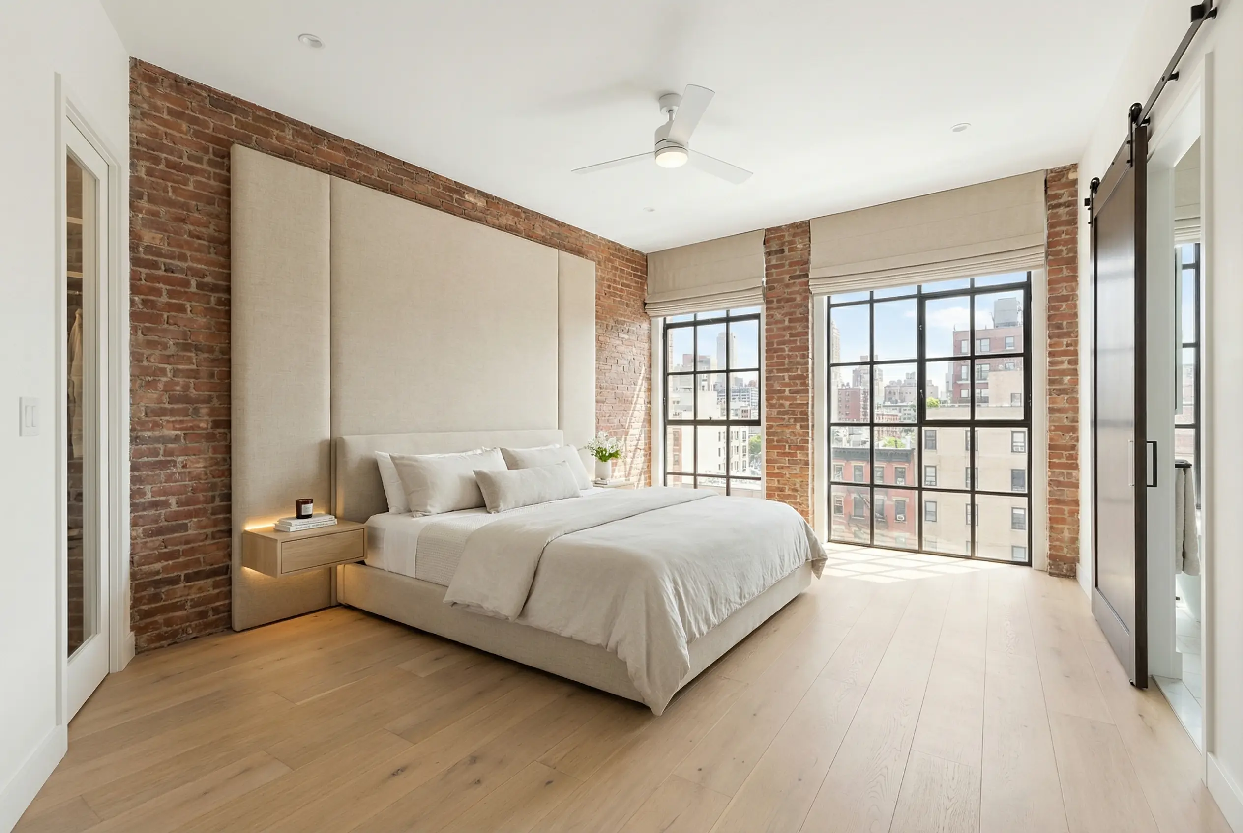 Modern Tribeca co-op bedroom renovation with exposed brick and floor-to-ceiling windows after board package approval
