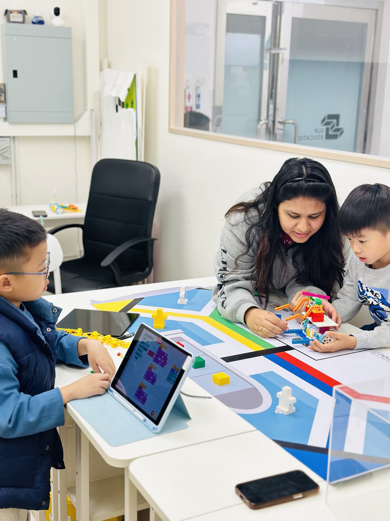 初小學生與老師在機械人場地一起學習