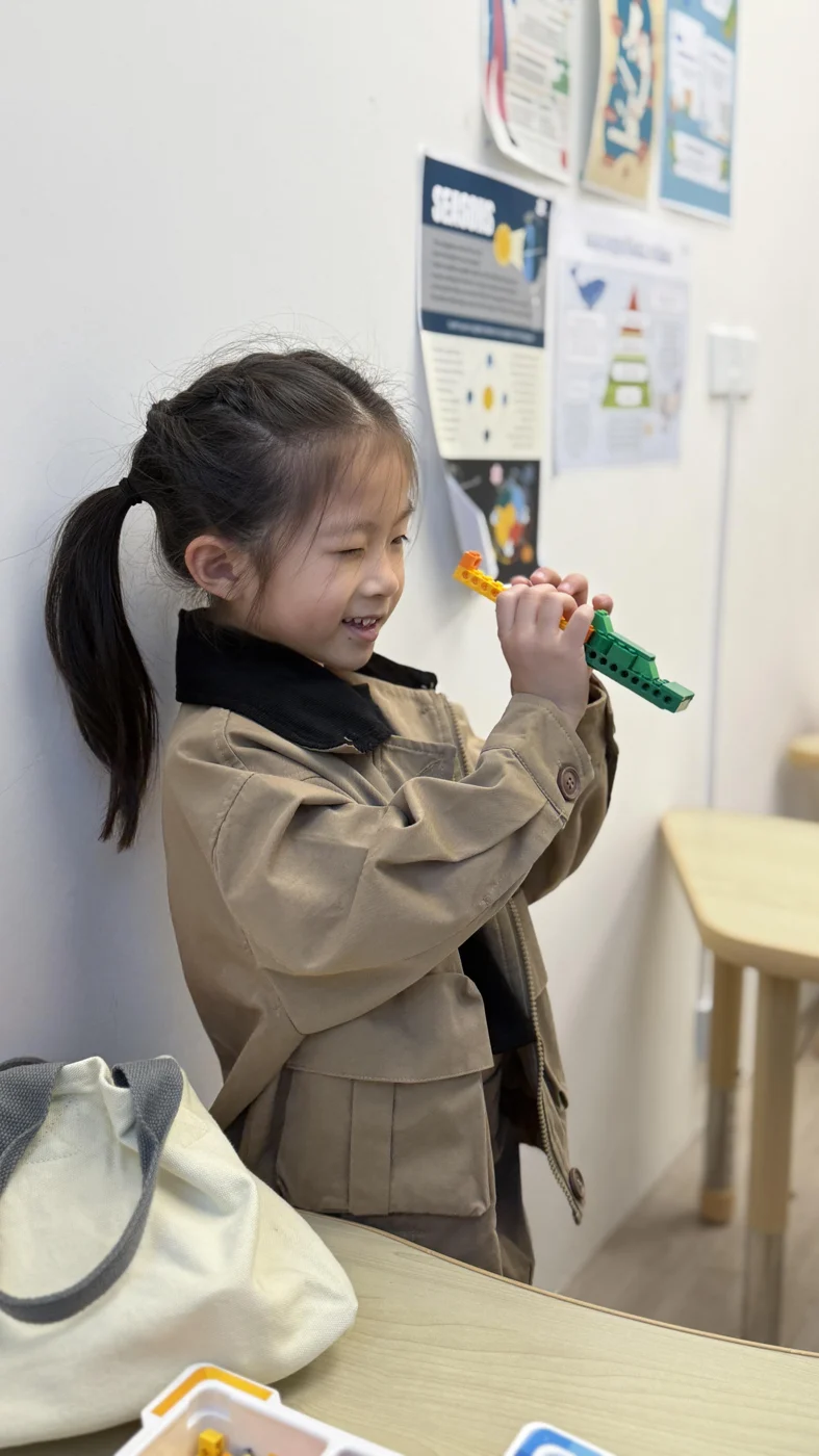 A student presenting at the front of the classroom