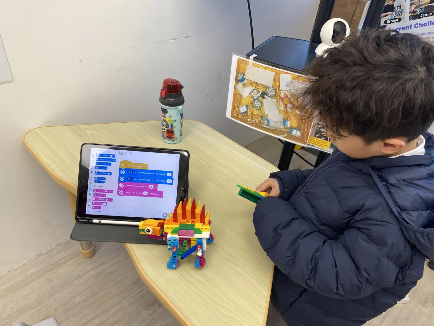 A student programming a LEGO model on a tablet