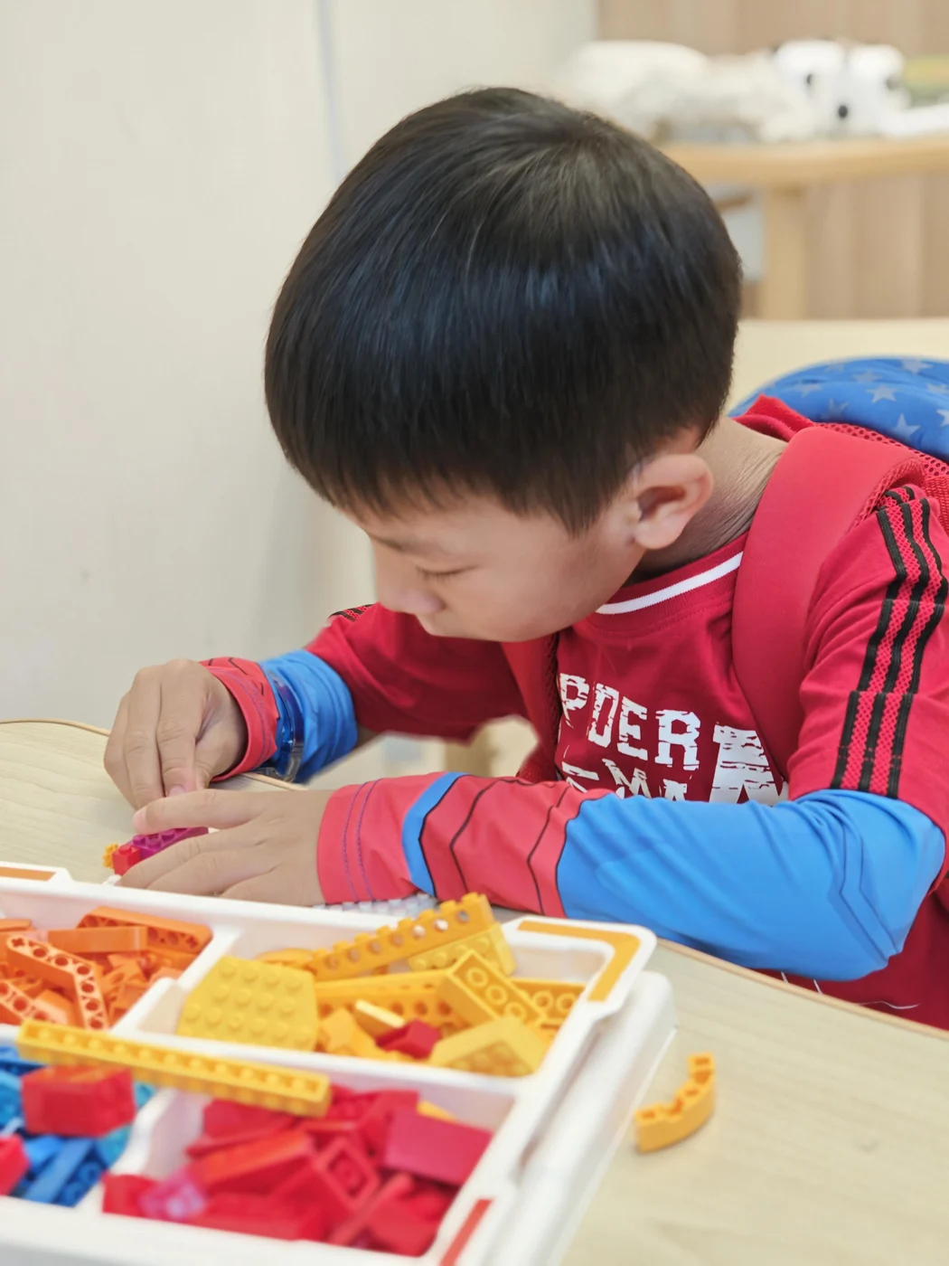 A student concentrating on a LEGO building activity