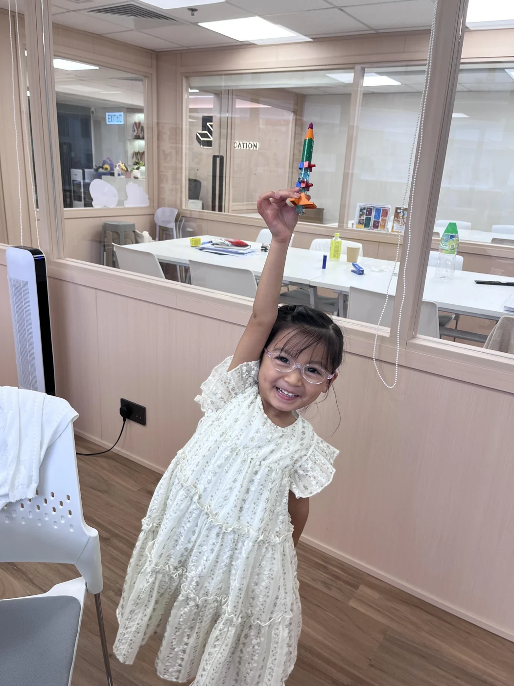 A student raising her space-themed creation