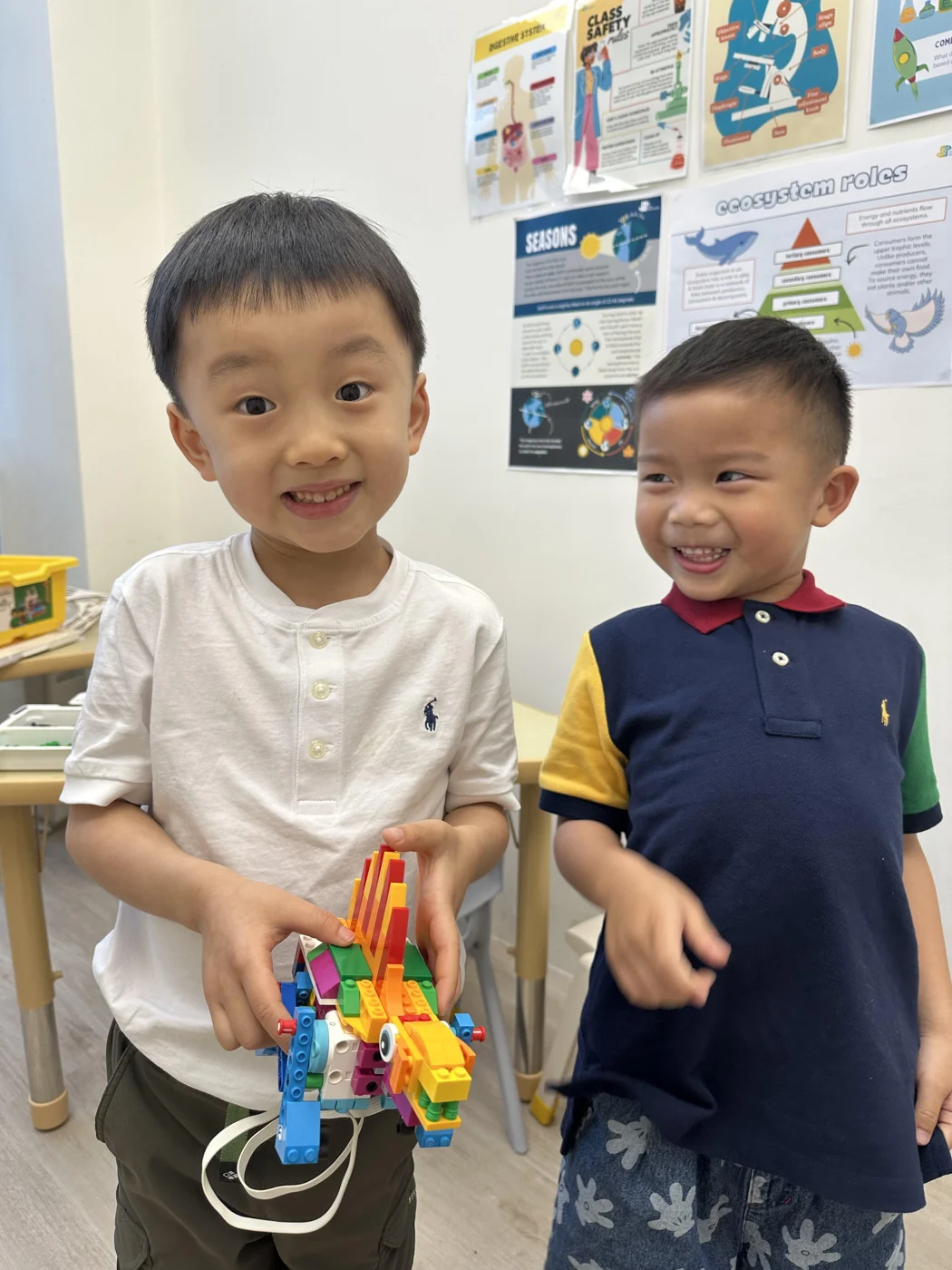 Two students holding a colourful LEGO model