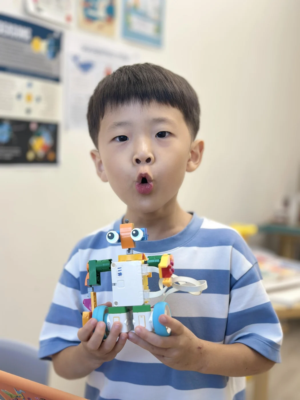 A student proudly showing a LEGO robot