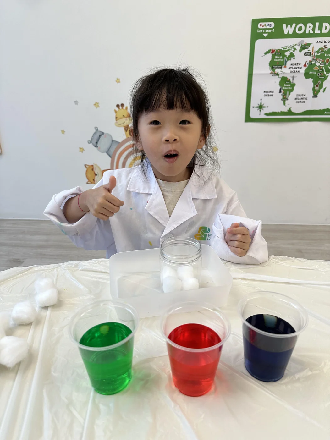 A young learner exploring a science experiment with coloured liquids