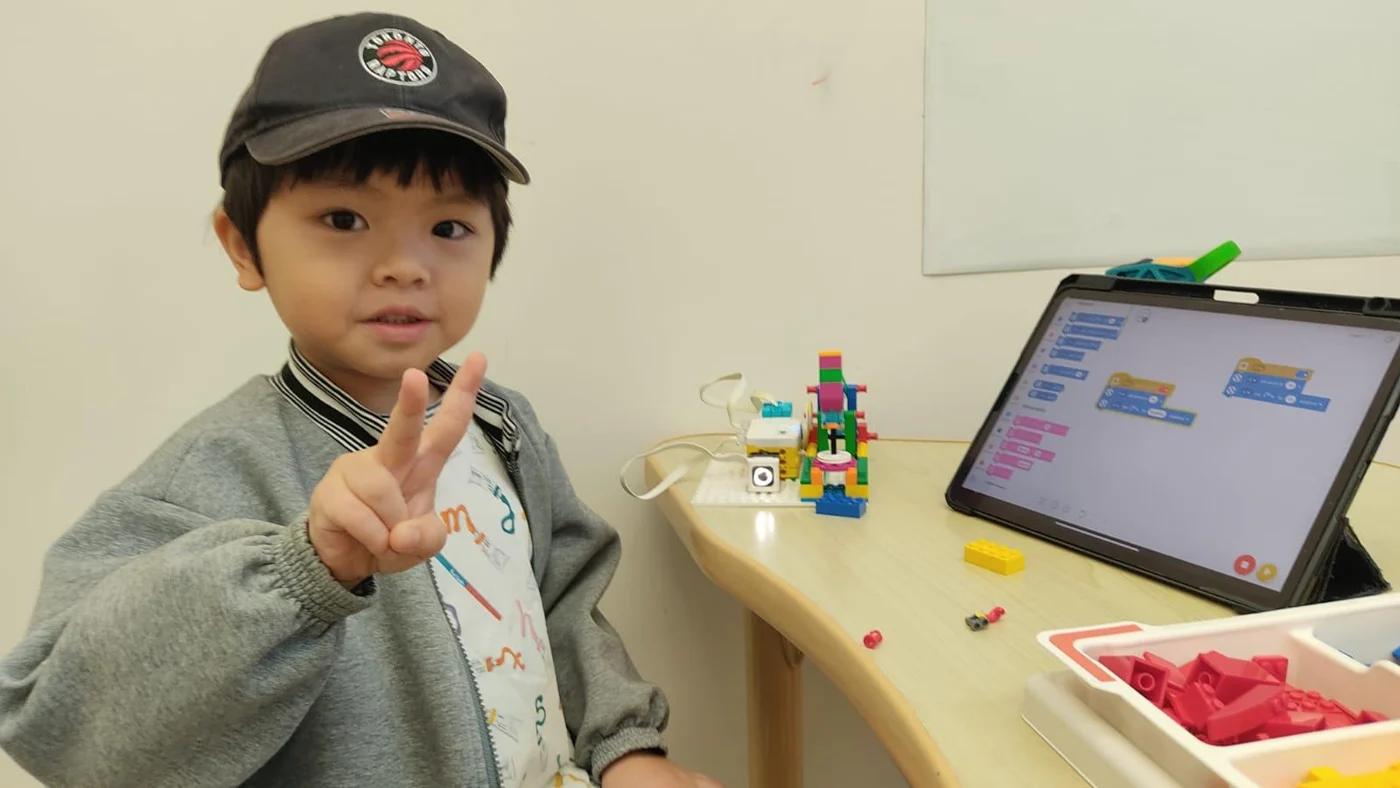 A student with a tablet and a LEGO model