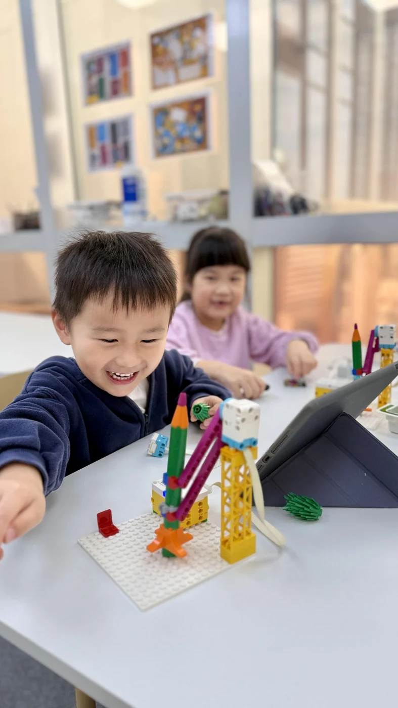 Two students exploring a colourful LEGO build together