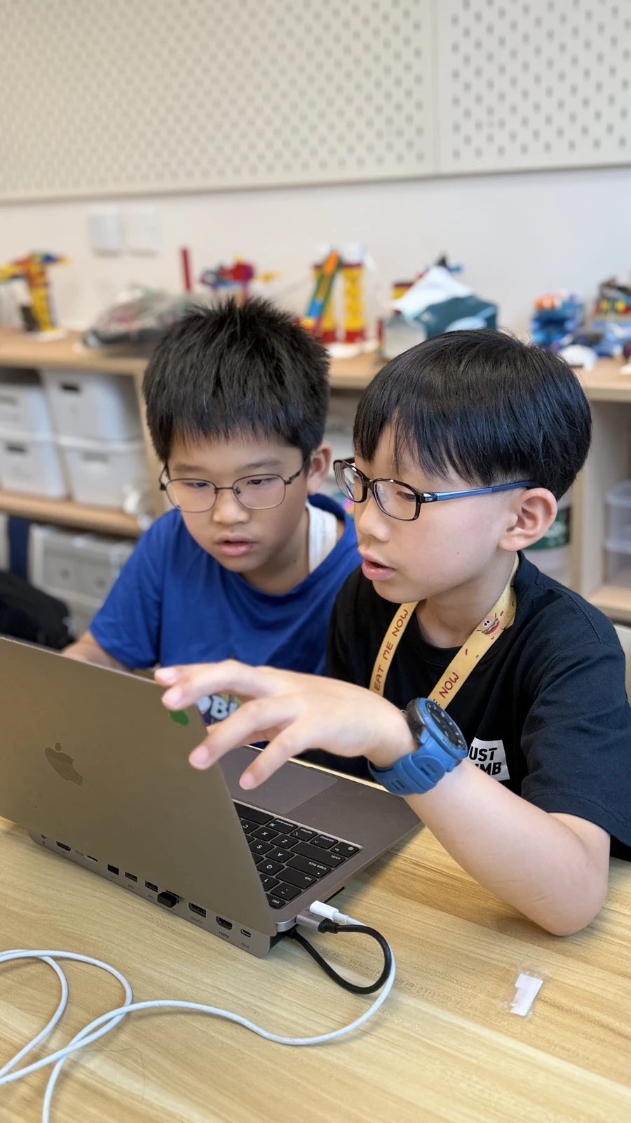 Two students researching together on a laptop