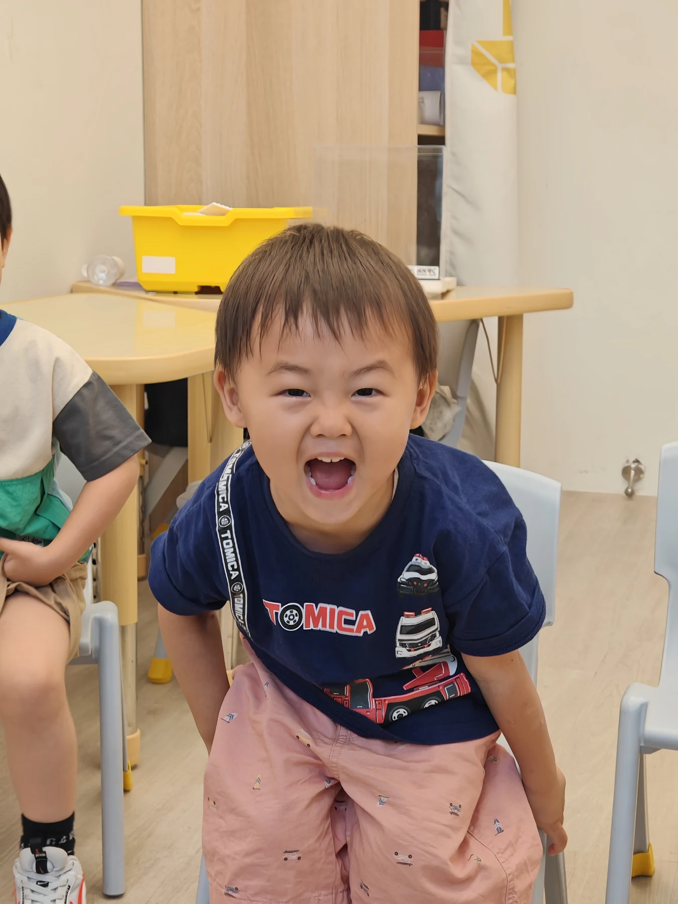A smiling child in the Little Coder classroom