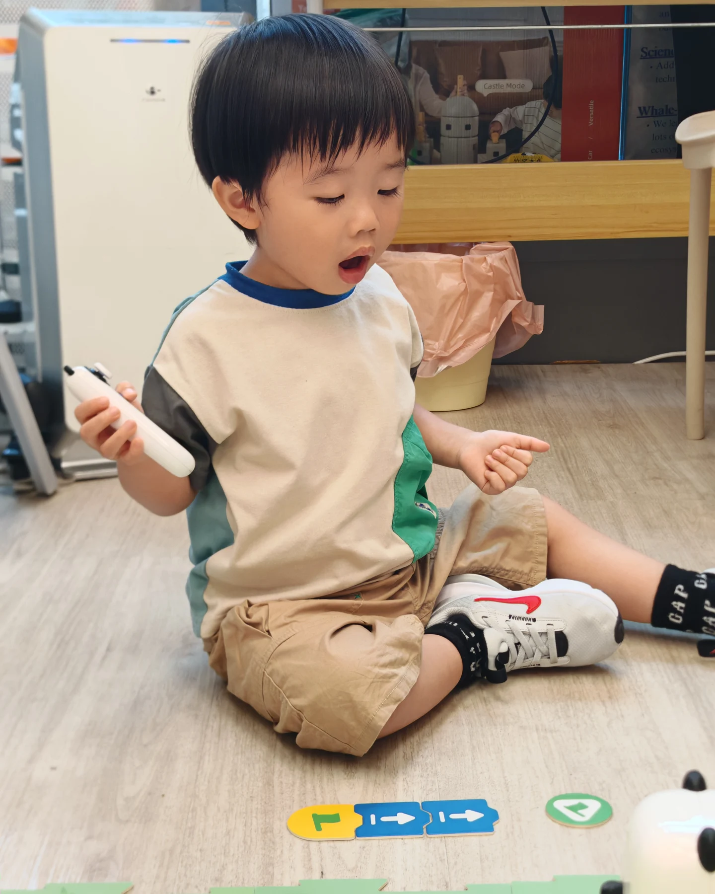 A child holding a controller beside a coding route