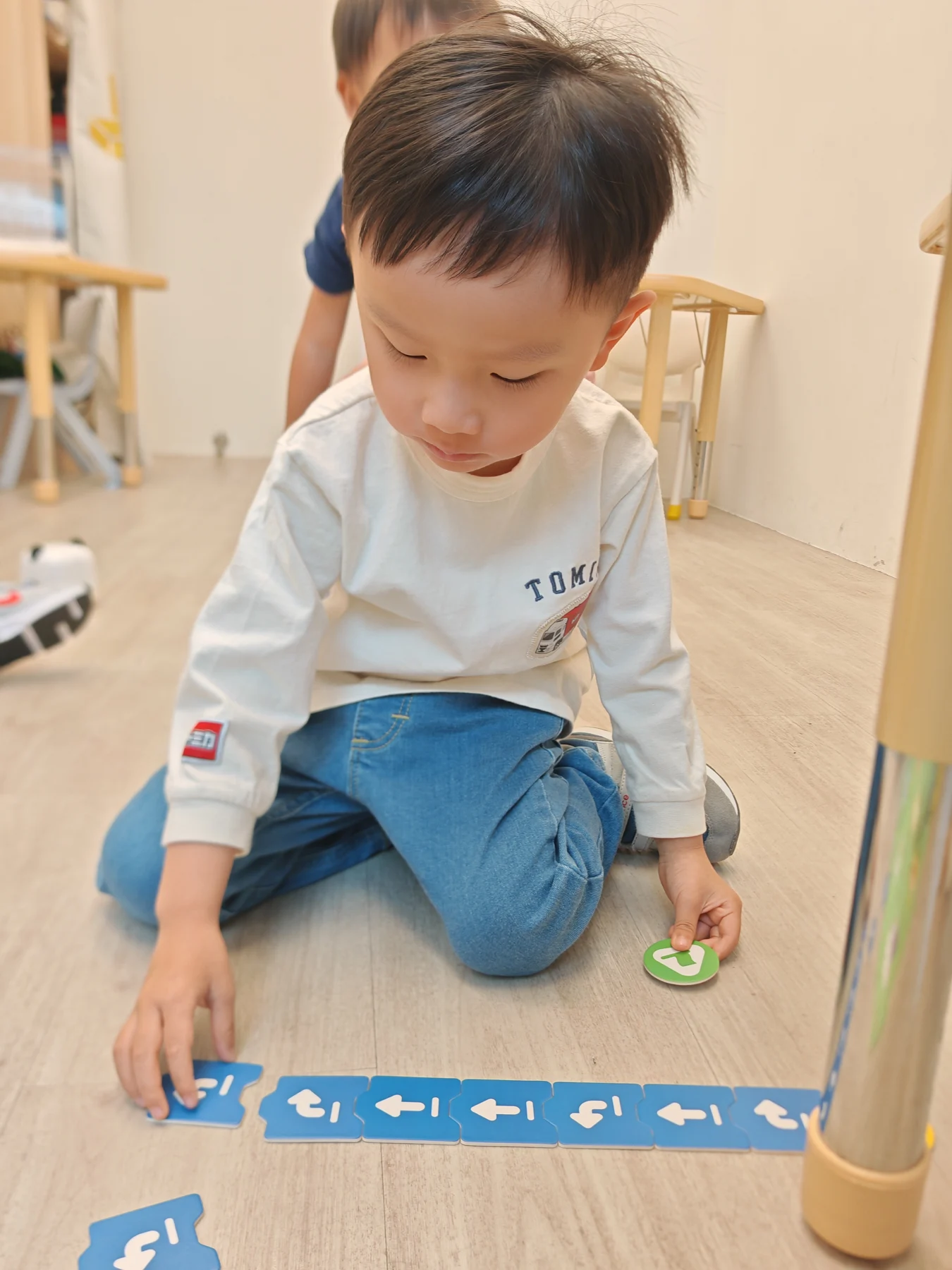 A child planning a sequence with physical coding cards