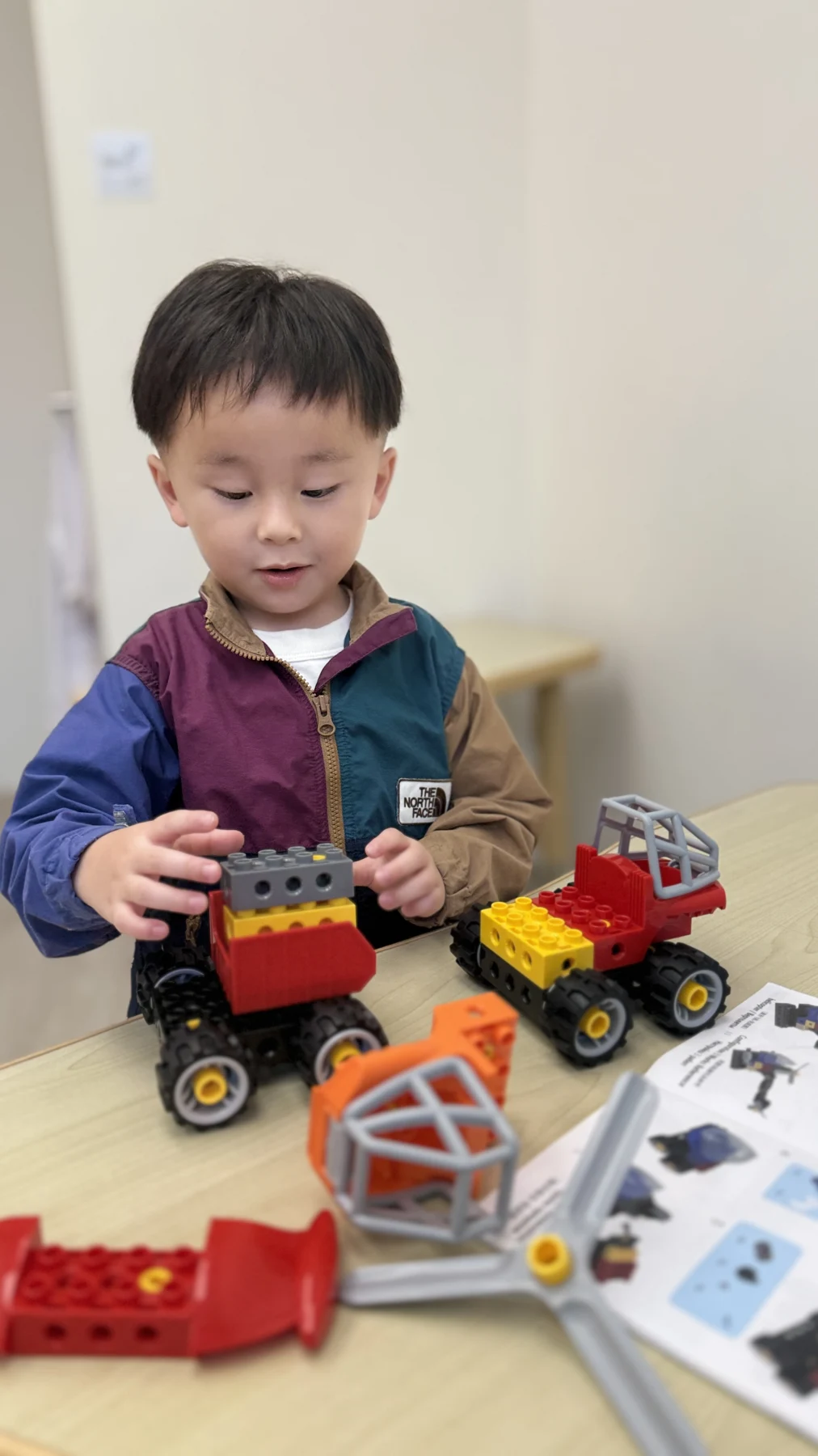 A child connecting large LEGO bricks to a vehicle