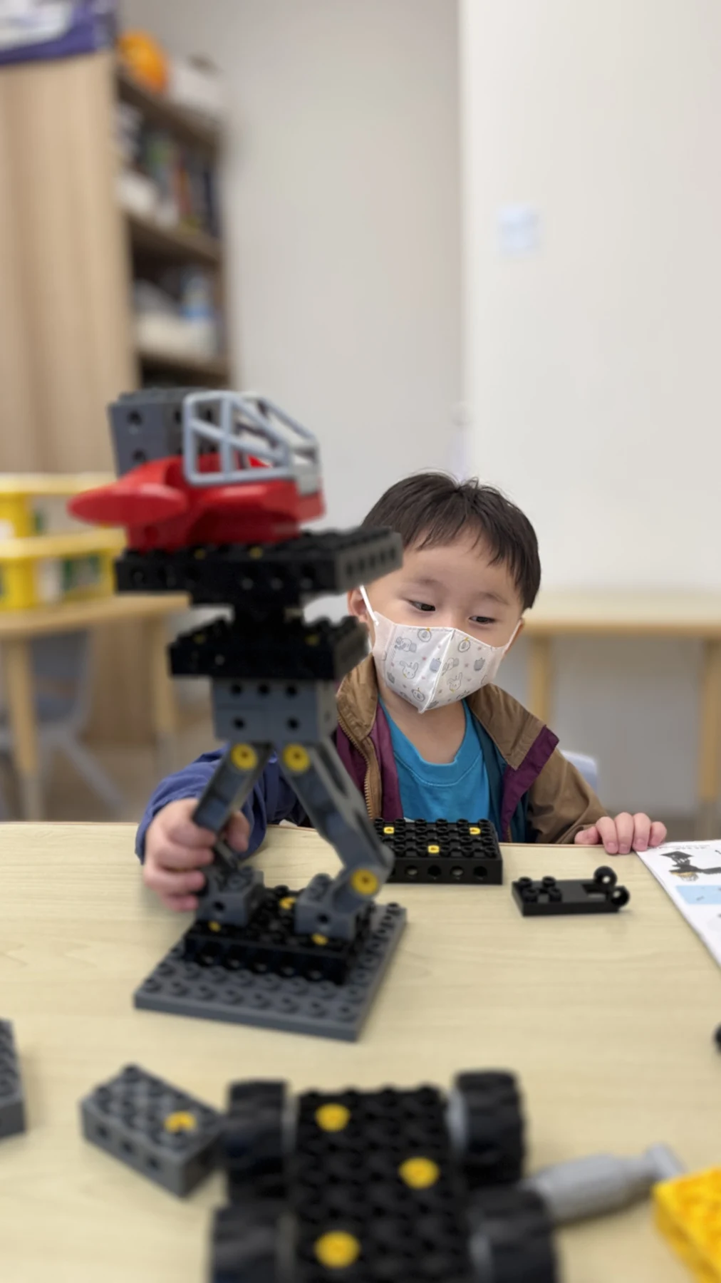 A child building a tall LEGO vehicle model