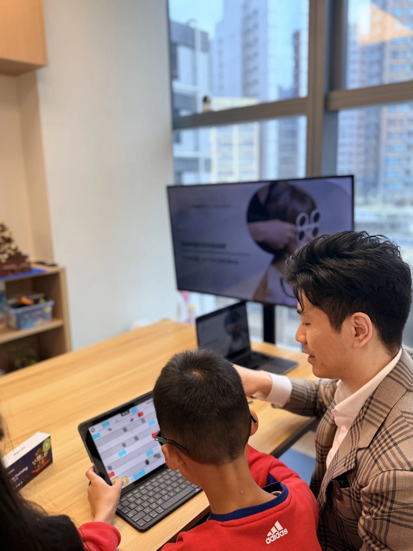 Jeff explaining a tablet activity to a child