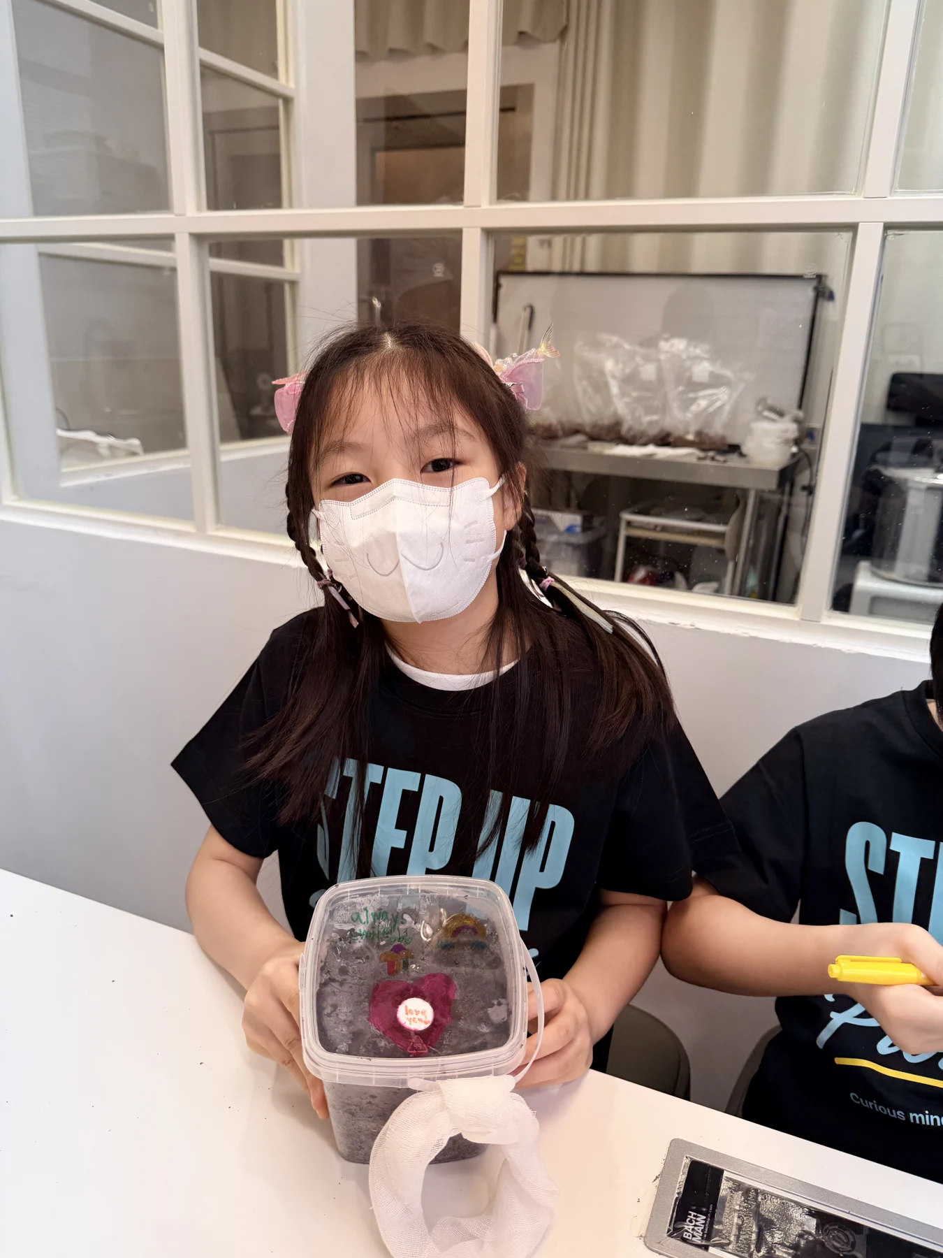 A student showing a take-home mushroom growing kit at Myconoko Lab