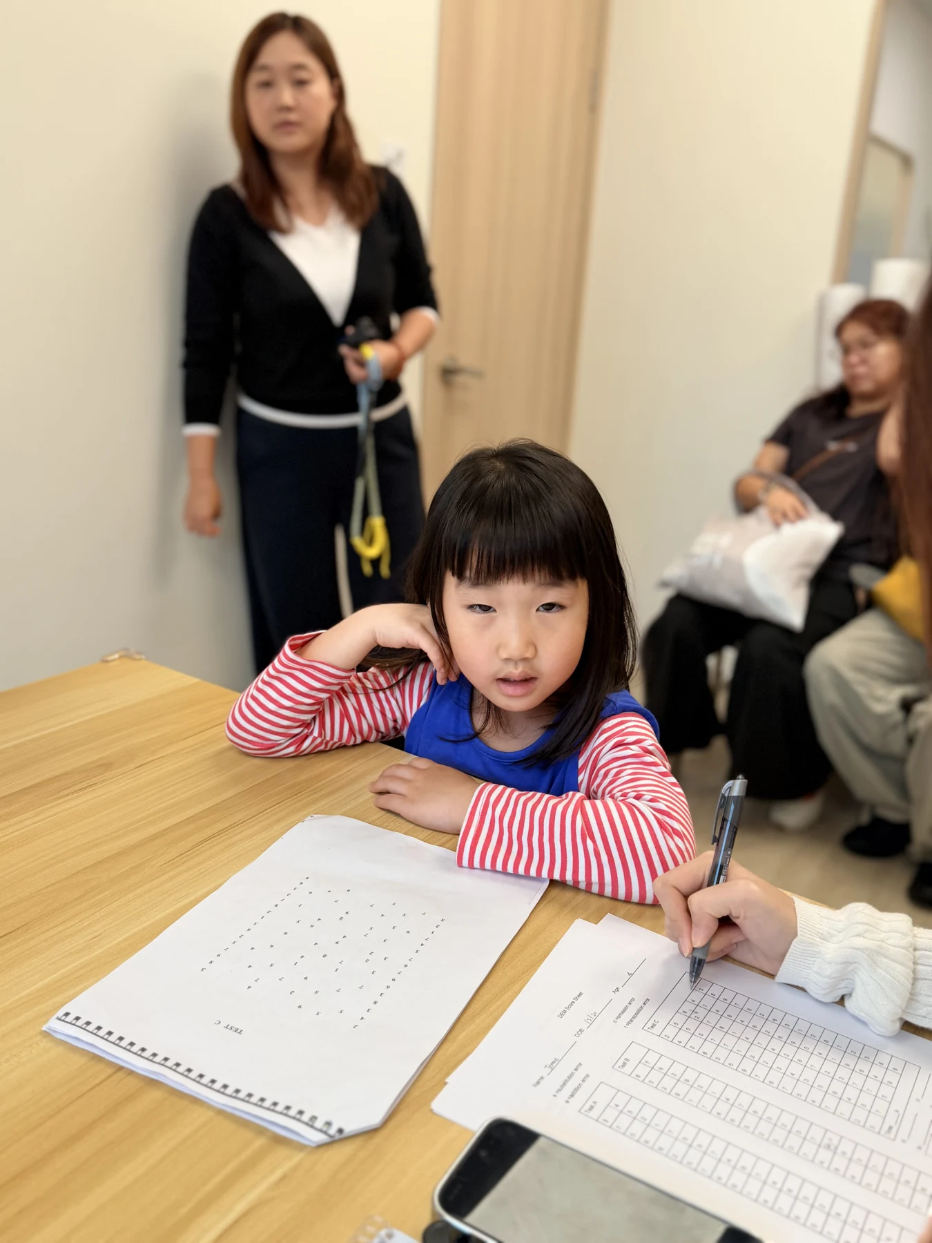 A participant trying a tabletop activity with adults nearby