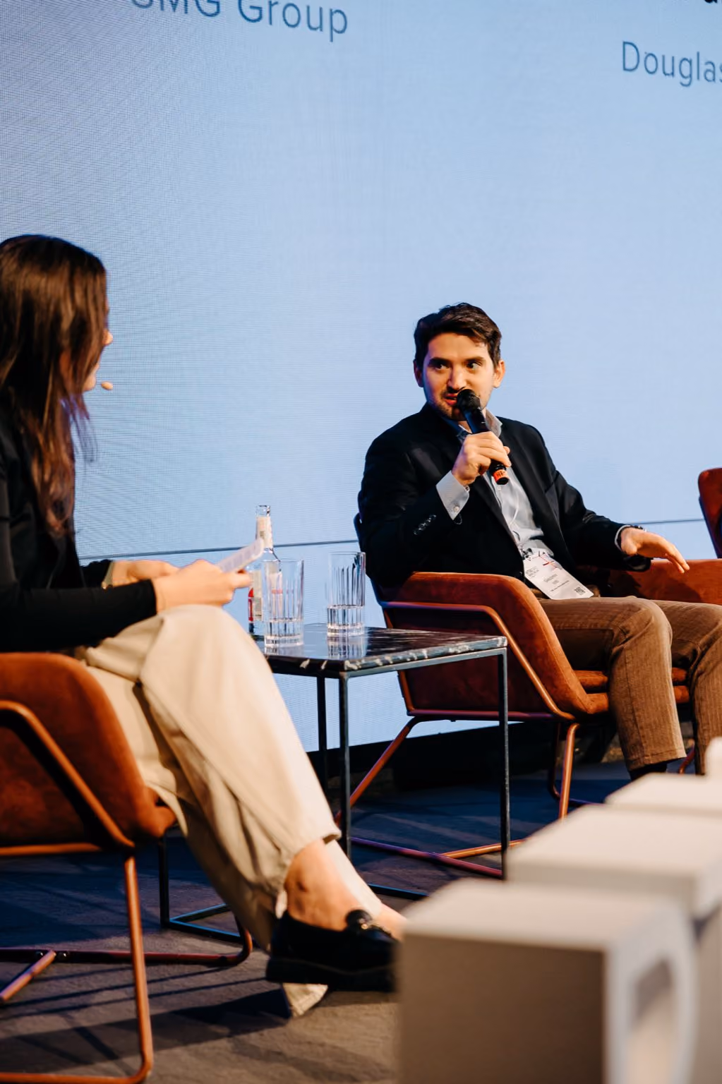 Giacomo Iotti holds a microphone while speaking at a panel about AI in marketing. The event was hosted at the RTB Days 2026 in Berlin, in April 2026