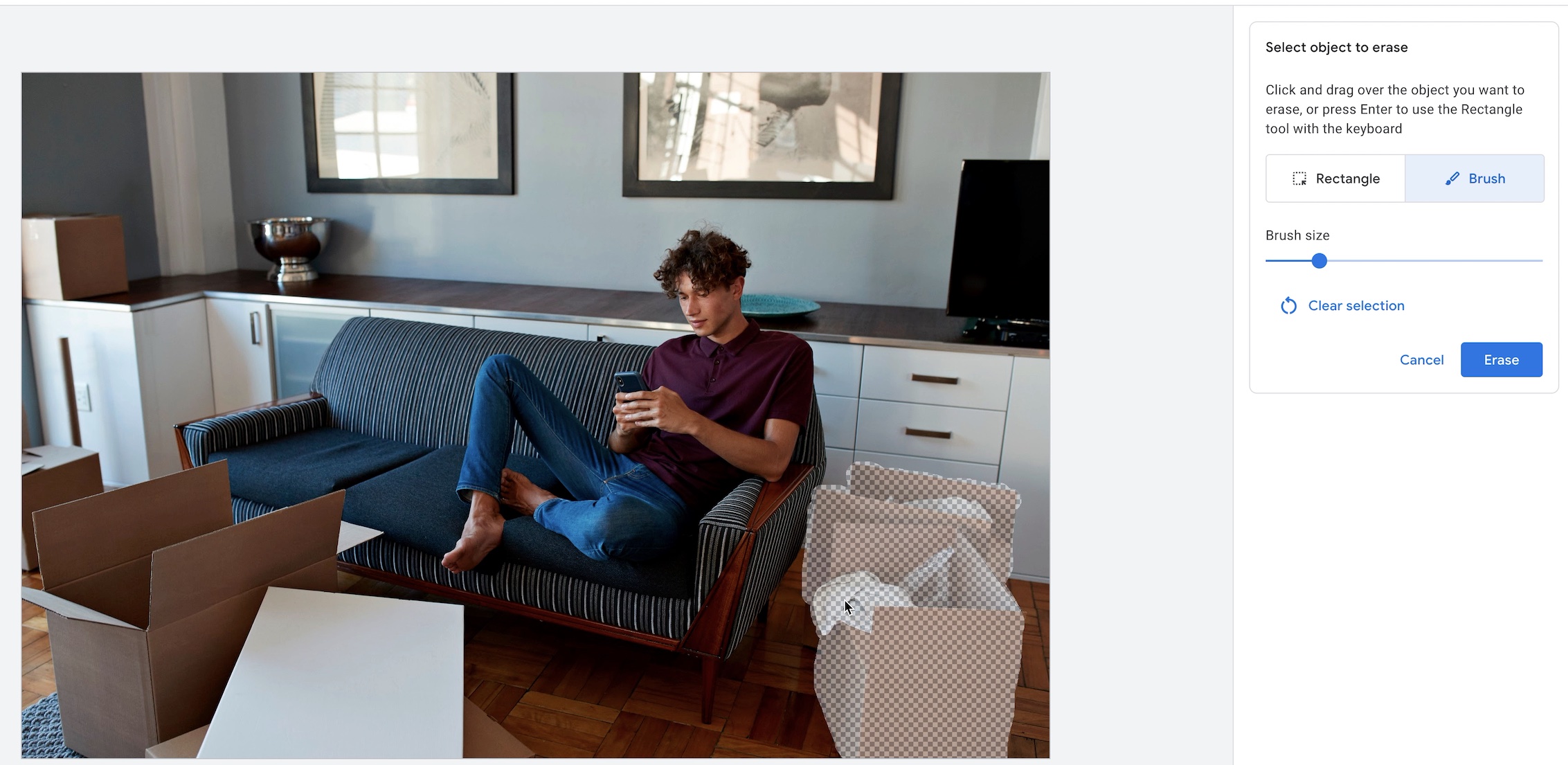 Google Ads' AI editor uses a brush to select an armchair for removal from a living-room photo.