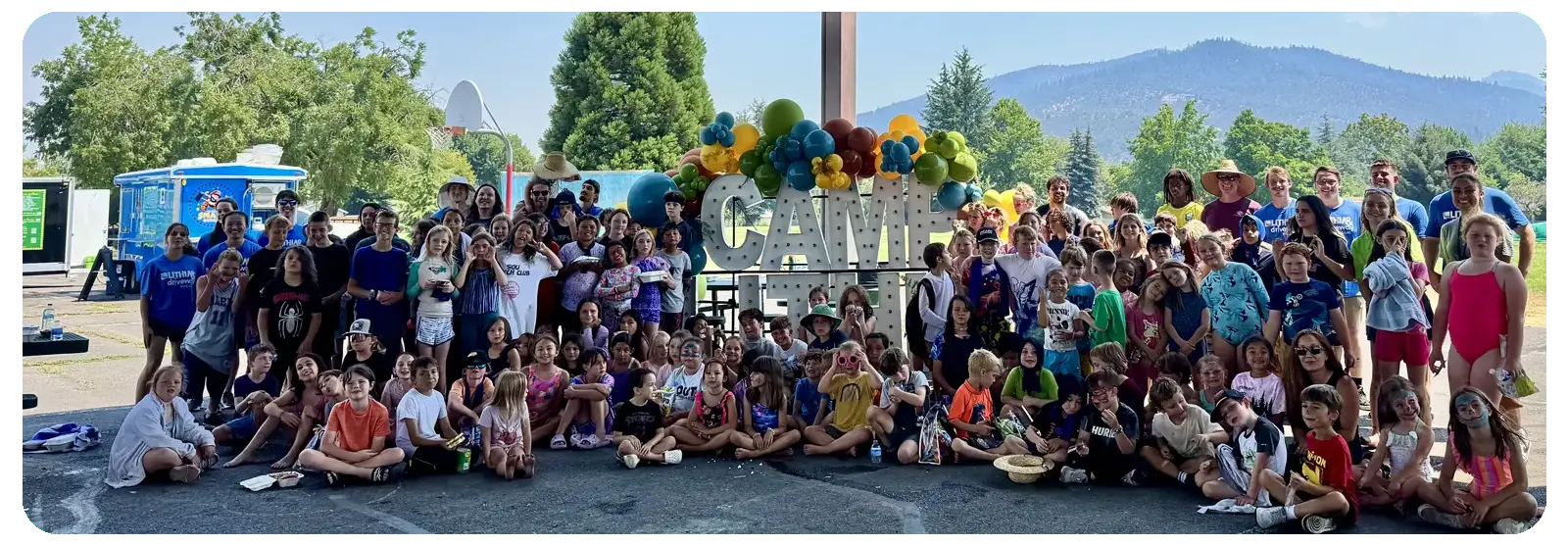 children and interns standing by a sign