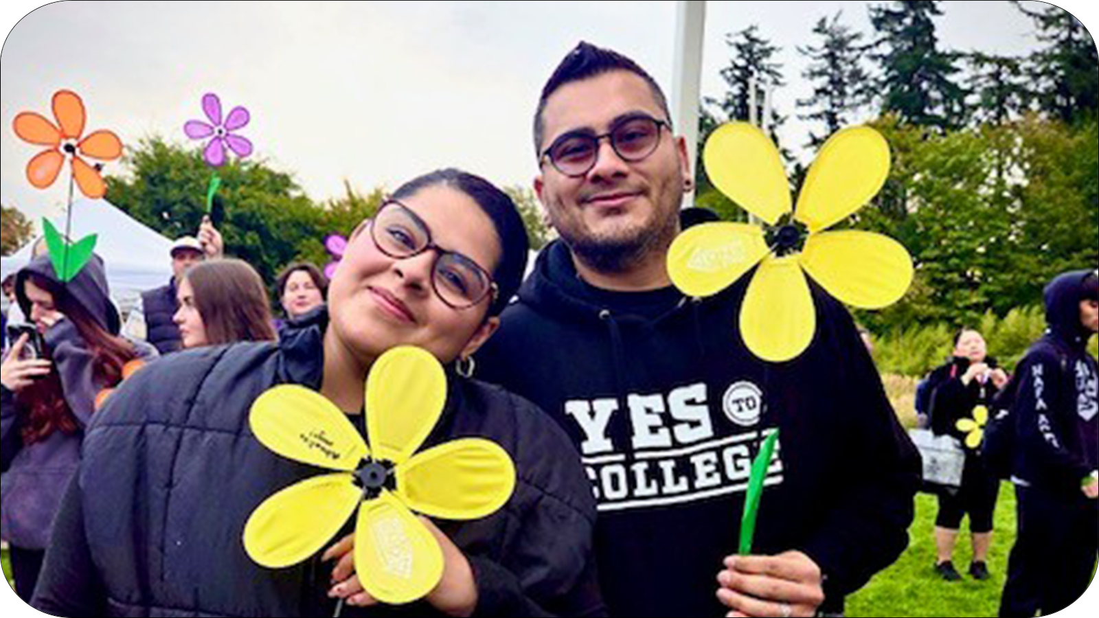 two people standing with a flower sign