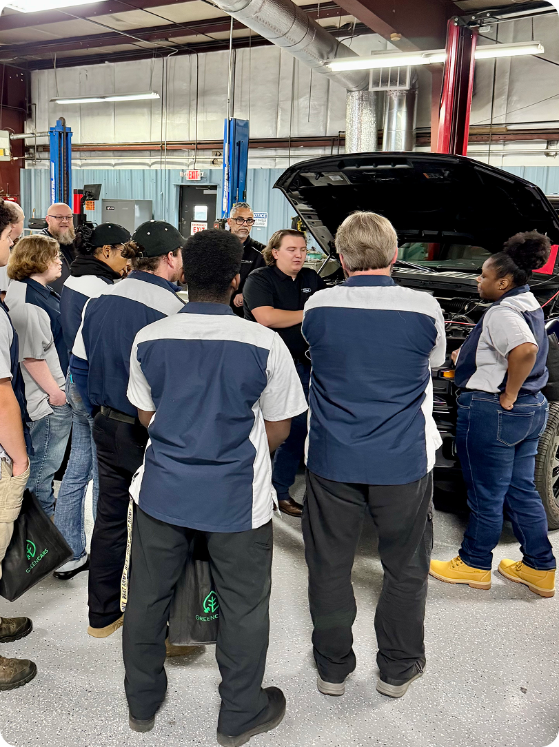 tech students standing with car 