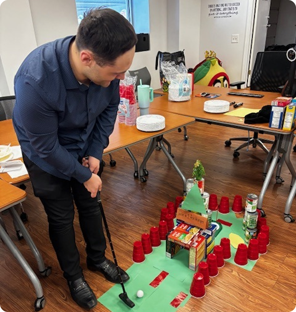 man mini golfing in an office setting