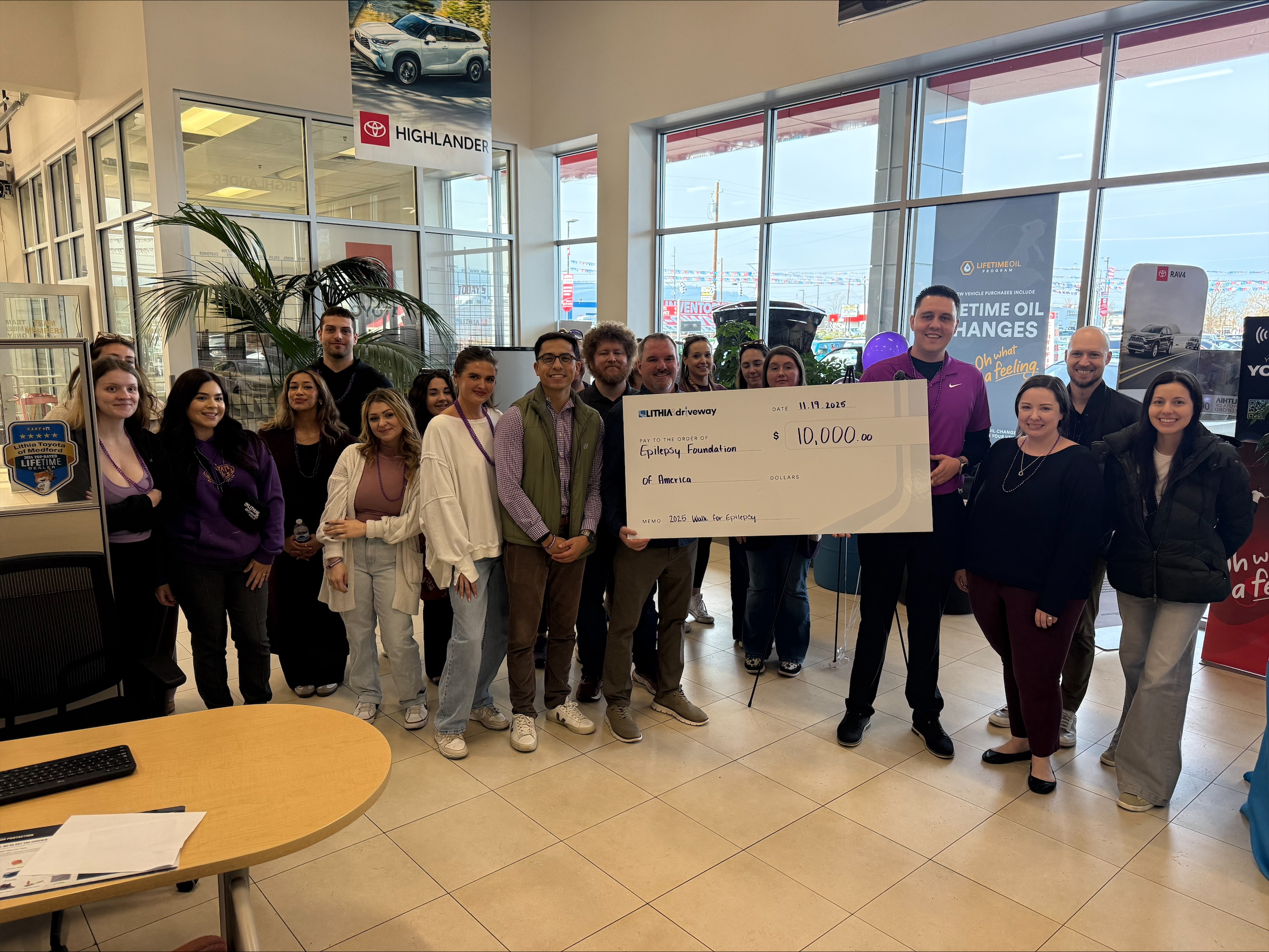 Dealership employers standing with large check 