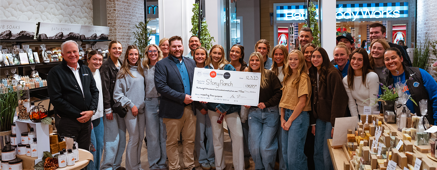 Group of people standing with a large check in a store