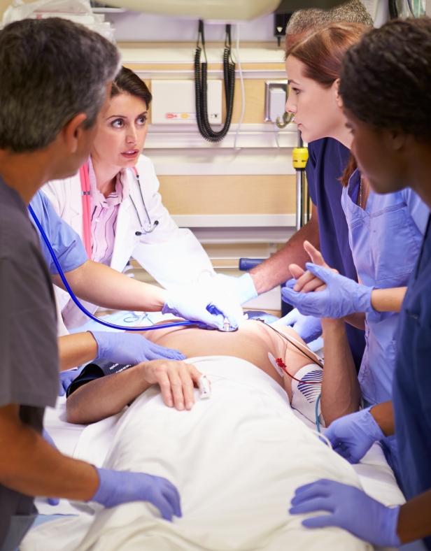 group of nurses and doctors work to save patient