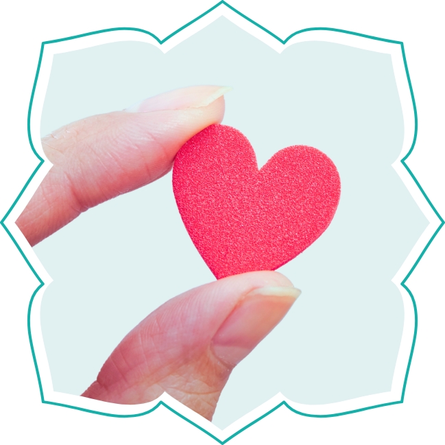 Finger halten ein kleines Herz aus Filz.