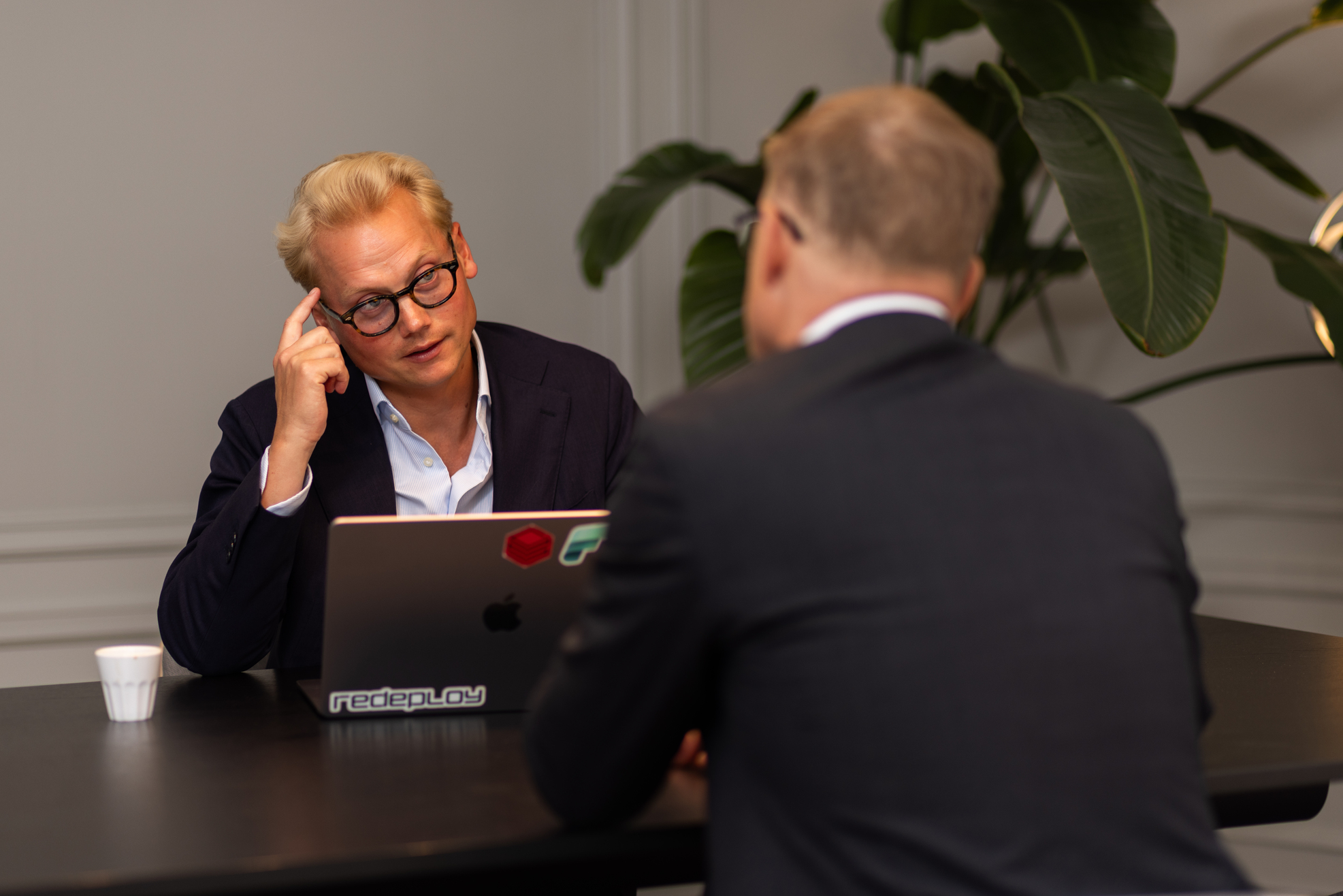 Oskar Dahl Aldeborn in conversation with a colleague, gesturing towards his head as he makes a point.