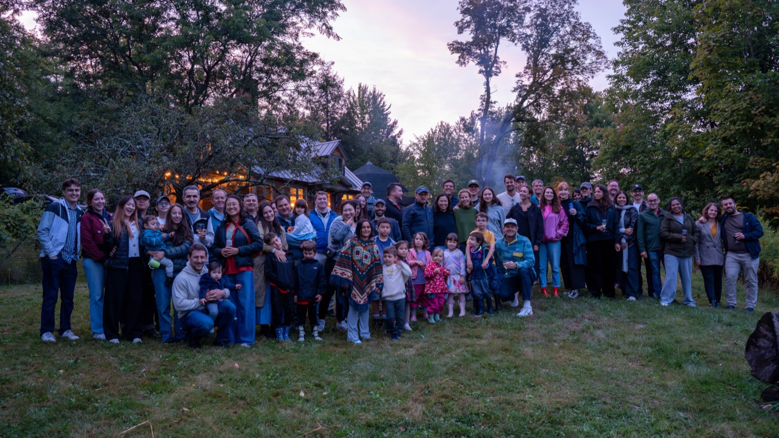 The Optable team and their families together outdoors at dusk.